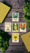 Green Glyphs Lenormand Card Spread on a wooden table with moss and a journal