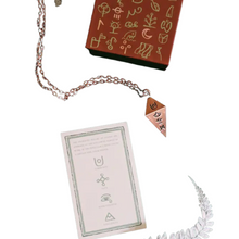 image of copper pendulum with glyphs