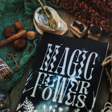 magic flowers book on wooden table with herbs witchy