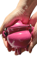 Hands holding a barbie pink cast iron mini cauldron