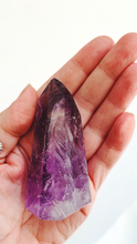 Hand holding a amethyst point 