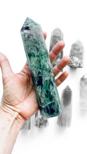 Hand holding a large green crystal fluorite tower point