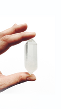 Hand holding a small double terminated crystal quartz stone