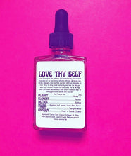 A bottle of Love Thy Self body and magical oil on a pink magenta background. 