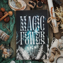 magic flowers book on wooden table with herbs and mushrooms 