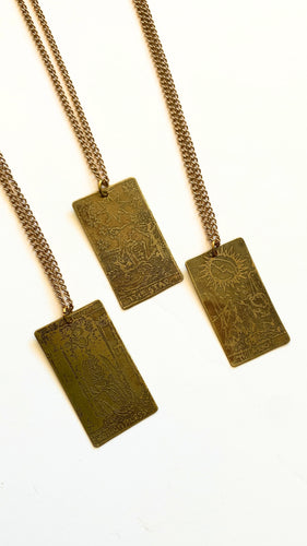 Brass necklace featuring an etched tarot card design, showcasing intricate artwork and a timeless finish